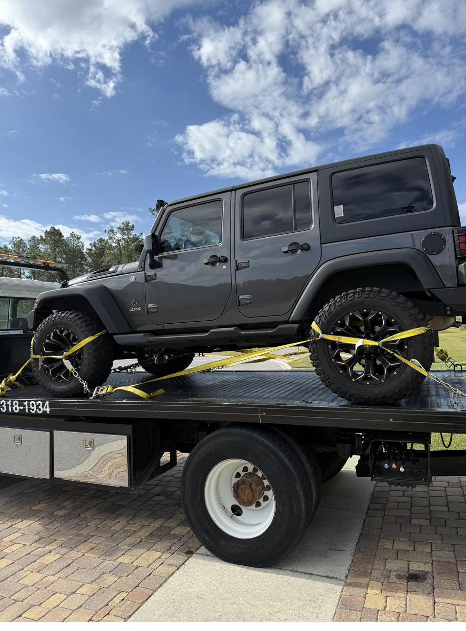 Gray Jeep Wrangler Unlimited loaded on flatbed
